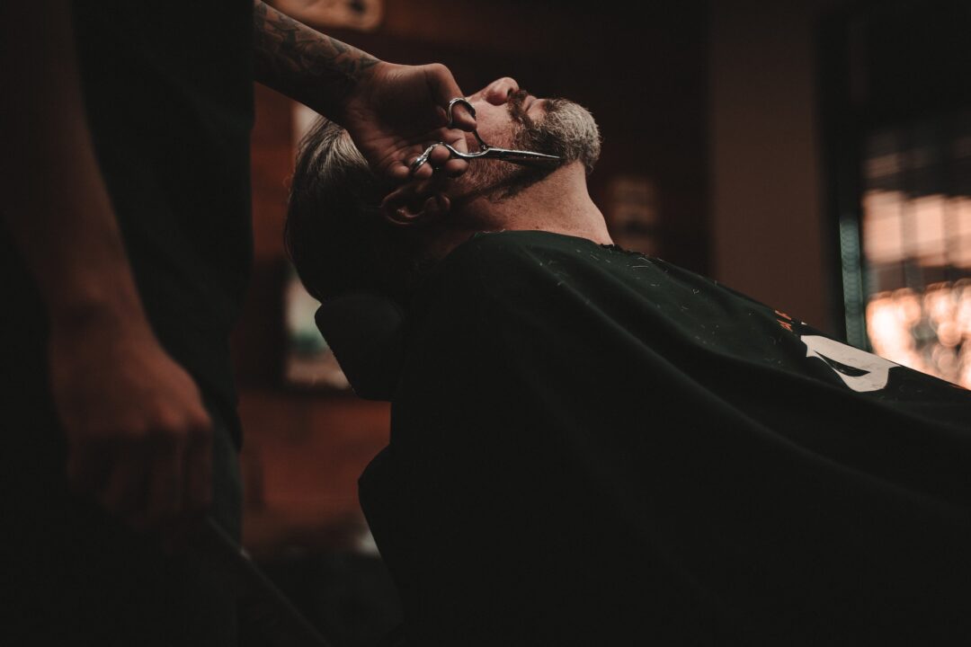 barber cutting a man's beard