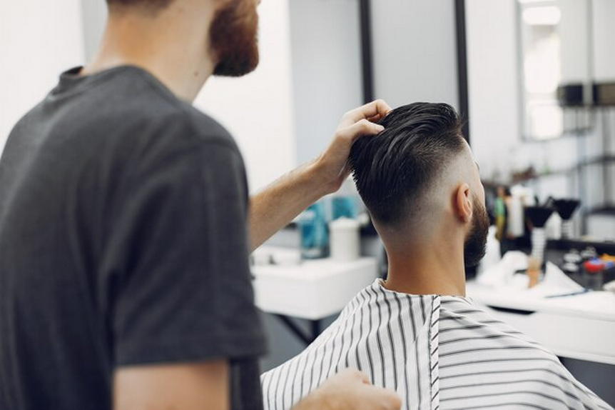 Barber styling client's hair.