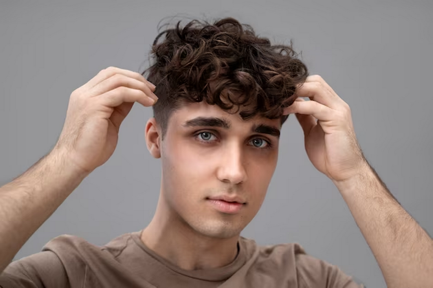 Curly-haired man styling his hair.