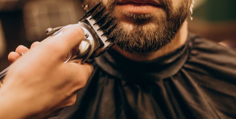 a man is getting his beard trimmed at a barbershop